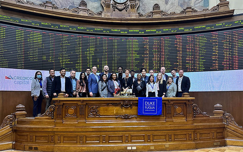 two dozen students posting in front of the ticker at the Santiago stock exchange during their residency